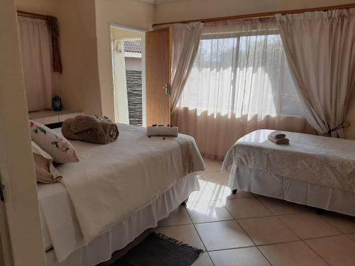 a bedroom with two beds and a window at Aloes Bush Stay in Hoedspruit