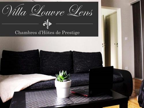 a living room with a couch and a laptop on a table at Villa Louvre Lens in Lens