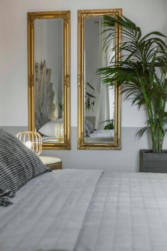 a bedroom with two mirrors and a bed at Makis Hotel in Skala Kefalonias