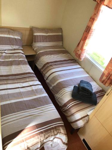 Dos camas en una habitación pequeña con una mochila. en Kernow Wishes en Newquay