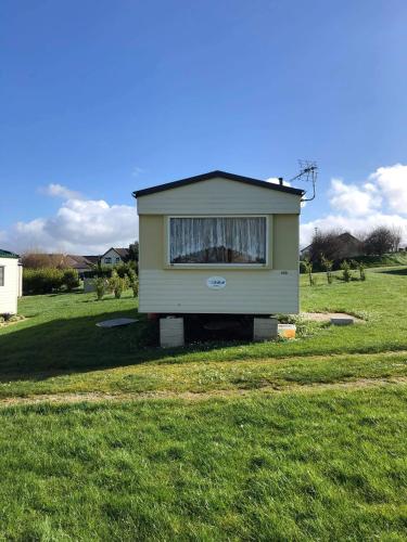 a tiny house sitting in a field of grass at Kernow Wishes in Newquay