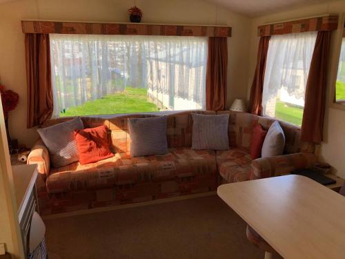 un sofá en una sala de estar con una gran ventana en Kernow Wishes, en Newquay