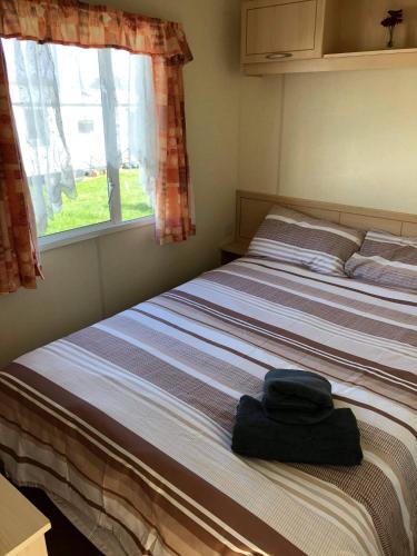 a bed sitting in a room with a window at Kernow Wishes in Newquay
