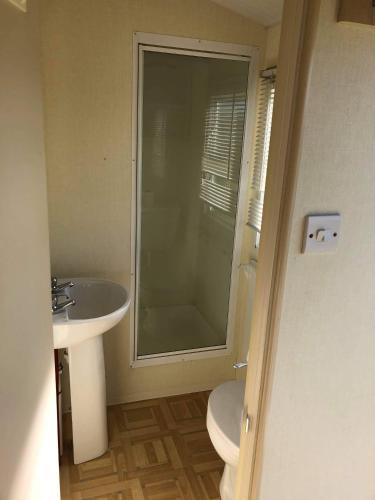 a bathroom with a toilet and a sink and a shower at Kernow Wishes in Newquay