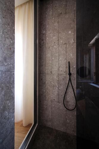 a bathroom with a shower with a shower curtain at Pànto - Rooftop boutique rooms in Palermo