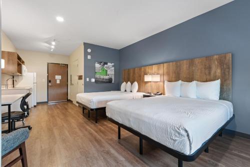 a hotel room with two beds and a kitchen at Extended Stay America Premier Suites - Port Charlotte - I-75 in Port Charlotte