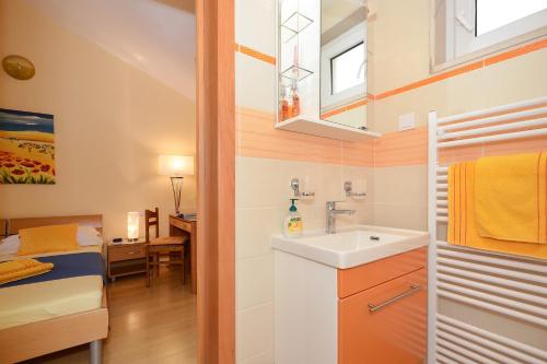 a small bathroom with a sink and a bedroom at Villa Fontana Apartment Olive in Bol