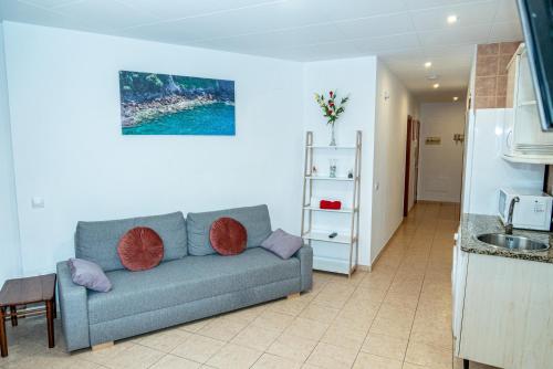 een woonkamer met een bank en een keuken bij Apartament Central in Lloret de Mar