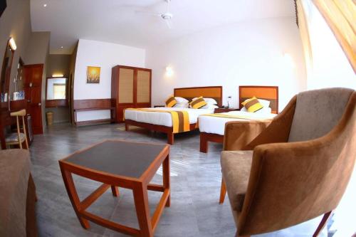 a hotel room with two beds and a couch at Spring Villas Kandy in Kandy