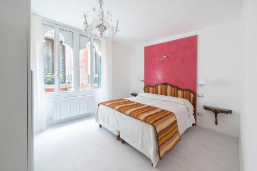 ein Schlafzimmer mit einem Bett und einer roten Wand in der Unterkunft Ca Marta Venice in Venedig