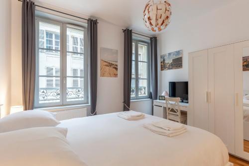 une chambre avec un lit blanc et un bureau dans l'établissement Paysages Normands, à Honfleur