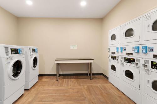 a laundry room with two washes and a table at Extended Stay America Premier Suites - Port Charlotte - I-75 in Port Charlotte