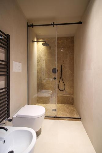 a bathroom with a shower and a toilet and a sink at Pànto - Rooftop boutique rooms in Palermo