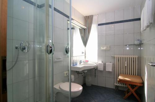 a bathroom with a toilet and a sink and a shower at City Hotel in Schopfheim