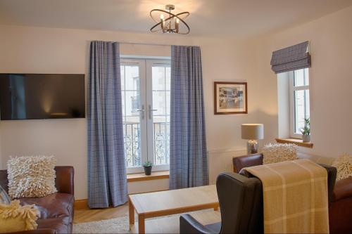 a living room with blue curtains and a couch at Royal Golf Apartments in Dornoch