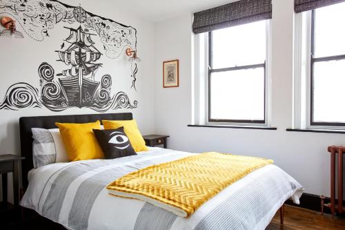 a bedroom with a large bed with yellow pillows at Jet Black Jewel in Whitby