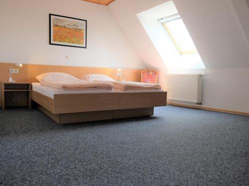 a bedroom with a bed and a window at Pension Steinle in Erbach