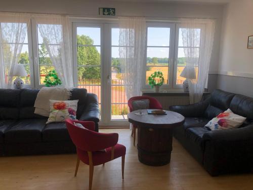 a living room with a couch and chairs and a table at Staby Gårdshotell in Högsby