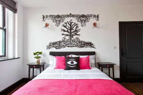 a bedroom with a pink bed with pink pillows at Jet Black Jewel in Whitby