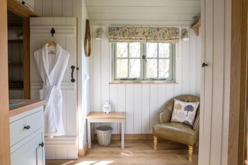 een kleine keuken met een stoel en een raam bij Perkins luxury shepherd huts in Nottingham