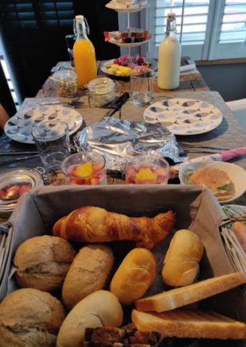 a table full of food with bread and pastries at B&B de Nieuwe Haven in Bunschoten