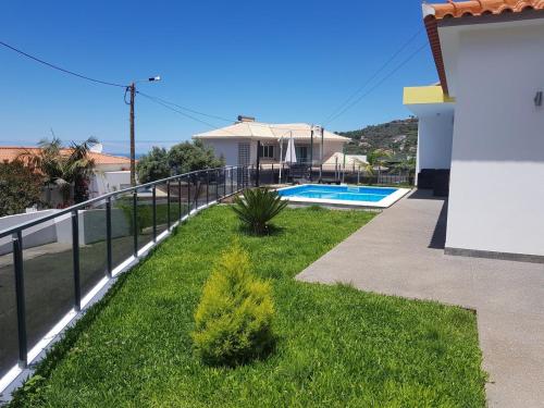 einen Balkon eines Hauses mit Pool in der Unterkunft migs'place in Arco da Calheta