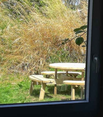 a picnic table and benches outside a window at Luz da Lúa - Casa del campo in Muxia