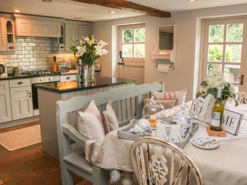 a kitchen with a table and chairs and a counter at Grange Cottage in Castleton