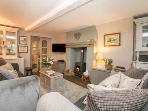 a living room with two couches and a fireplace at Grange Cottage in Castleton
