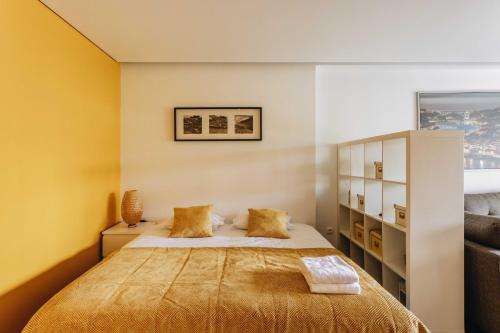 ポルトにあるESM Rental - Rosario's Cozy Studioのベッドルーム1室(黄色い壁のベッド1台付)