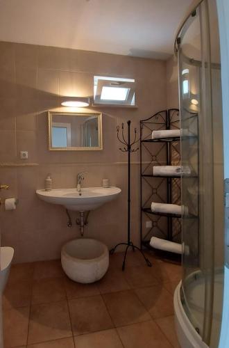 a bathroom with a sink and a mirror and a shower at Apartments Coral of Dubrovnik in Dubrovnik