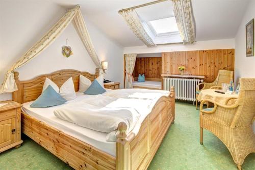 Schlafzimmer mit einem großen Holzbett und einem Dachfenster in der Unterkunft Steigmühle Pension Garni in Füssen