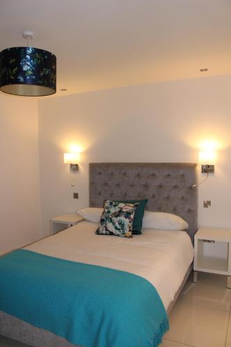 een slaapkamer met een groot bed met 2 nachtkastjes bij Blossom lane in Woodford