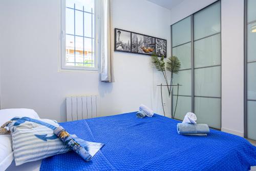 une chambre avec un lit bleu avec des serviettes dessus dans l'établissement GUISOL - Typical Nice 3 Bedroom AC near Port, à Nice