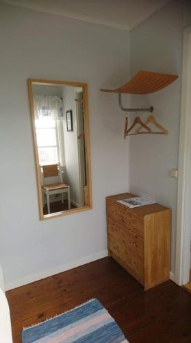 a room with a mirror and a wooden dresser at Vandrarhemmet Lotsen in Dalarö