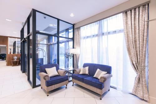 a lobby with two chairs and large windows at Ramsey Park Hotel in Ramsey