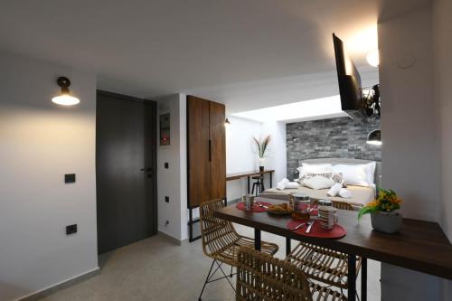 a living room with a table and a room with a bed at Orion Eco Suites in Karteros