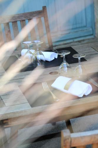 a wooden table with glasses and napkins on it at Logis Hostellerie de l'Abbaye in Celles-sur-Belle