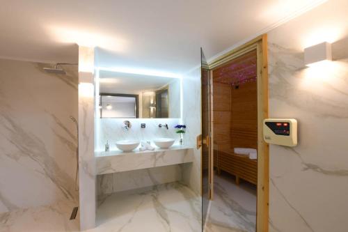 a bathroom with two sinks and a mirror at Orion Eco Suites in Karteros
