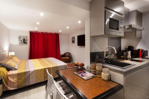 a small room with a bed and a kitchen at LE PALMIER in Coulounieix-Chamiers