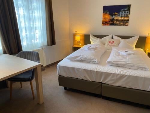 a hotel room with a bed with white pillows at Horchem Hotel-Restaurant-Café-Bar in Monschau