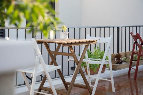 - Balcón con mesa de madera y 2 sillas en Alojamiento rural La Moravieta, en Pozoamargo