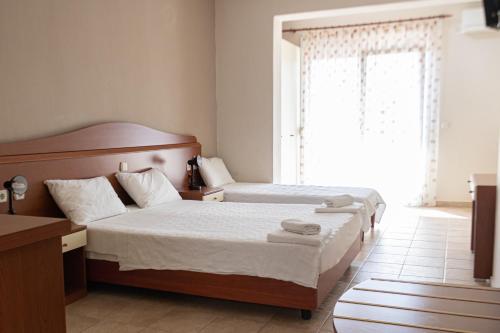 a hotel room with two beds and a window at JJ Rooms luxury apartments in Kallithea Halkidikis
