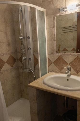 a bathroom with a sink and a shower at JJ Rooms luxury apartments in Kallithea Halkidikis