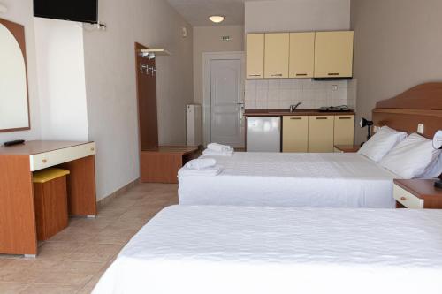 a hotel room with two beds and a flat screen tv at JJ Rooms luxury apartments in Kallithea Halkidikis
