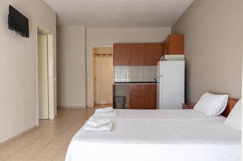 a bedroom with two beds and a white refrigerator at JJ Rooms luxury apartments in Kallithea Halkidikis