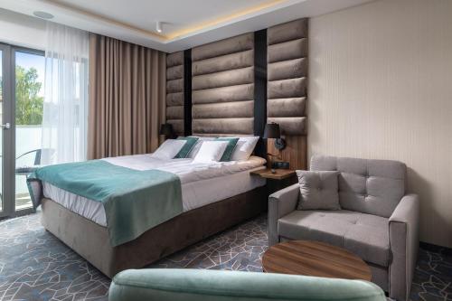 a hotel room with a bed and a chair at Love Sopot Residence in Sopot