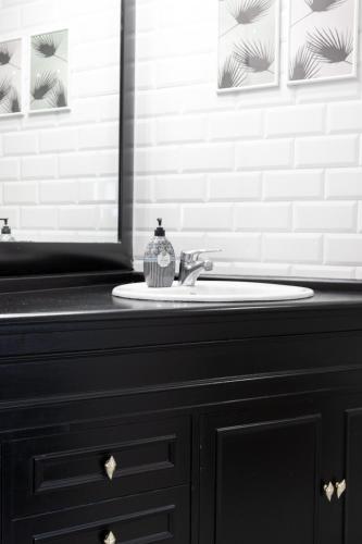 a black bathroom with a sink and a mirror at Apt in Neguri, 5 min from the beach & metro in Getxo