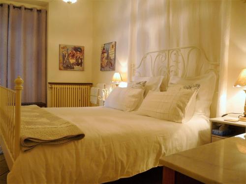 a bedroom with a large bed with white sheets and pillows at Chez Ed&egrave;ll in Monpazier