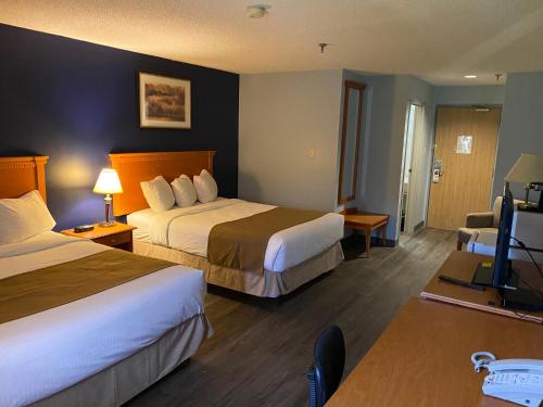 Slave LakeにあるNorthern Star Hotel & Convention Centerのベッド2台、薄型テレビが備わるホテルルームです。